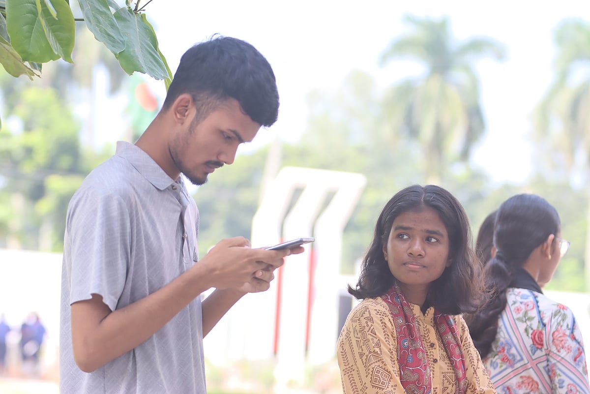 Students check their results on mobile phones after the HSC results are published. Photo taken at Police Lines School and College ground in Rangpur on 16 October 2025. 