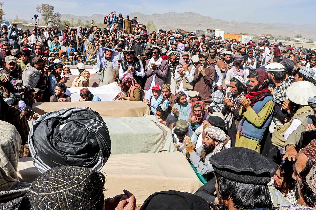 Afghan relatives and mourners surround coffins of victims, killed in aerial strikes by Pakistan, during a funeral ceremony at a cemetery in the Urgun district of Paktika province on October 18, 2025