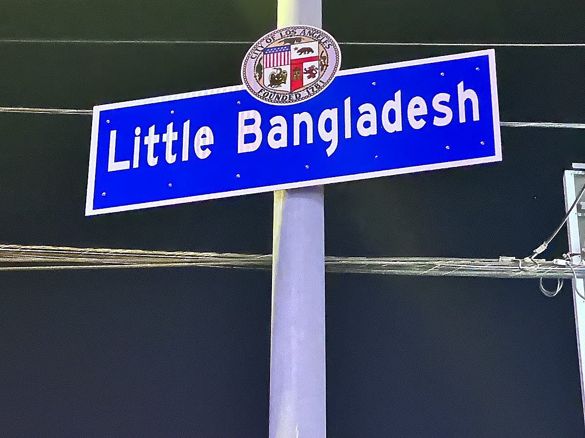 A blue signboard with 'Little Bangladesh' written on it.