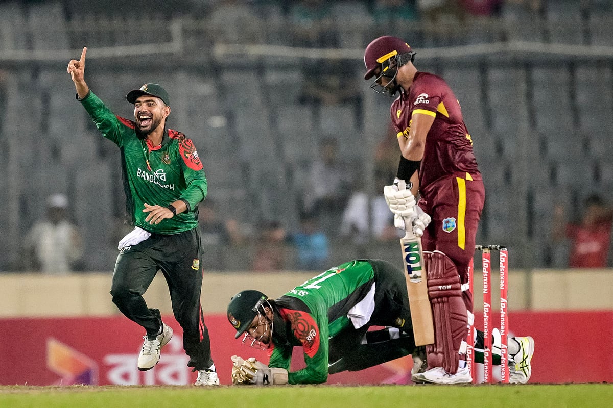 Bangladesh's wicketkeeper Nurul Hasan (C) takes a catch to dismiss West Indies' Brandon King (R) during the first one-day international (ODI) cricket match between Bangladesh and West Indies at the Sher-e-Bangla National Cricket Stadium in Dhaka on 18 October 2025