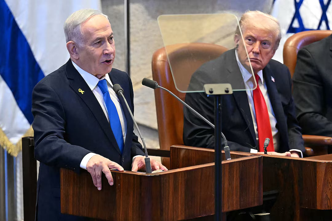 US President Donald Trump listens to Israeli Prime Minister Benjamin Netanyahu as he addresses the Knesset, in Jerusalem on 13 October, 2025. 