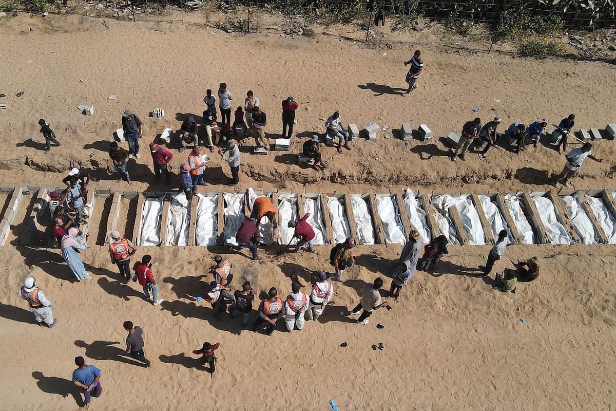 This aerial view shows Palestinians burying 54 unidentified bodies in a cemetery in Deir al-Balah, in the central Gaza Strip, on October 22, 2025, after they were returned by Israel under a US-brokered ceasefire deal.