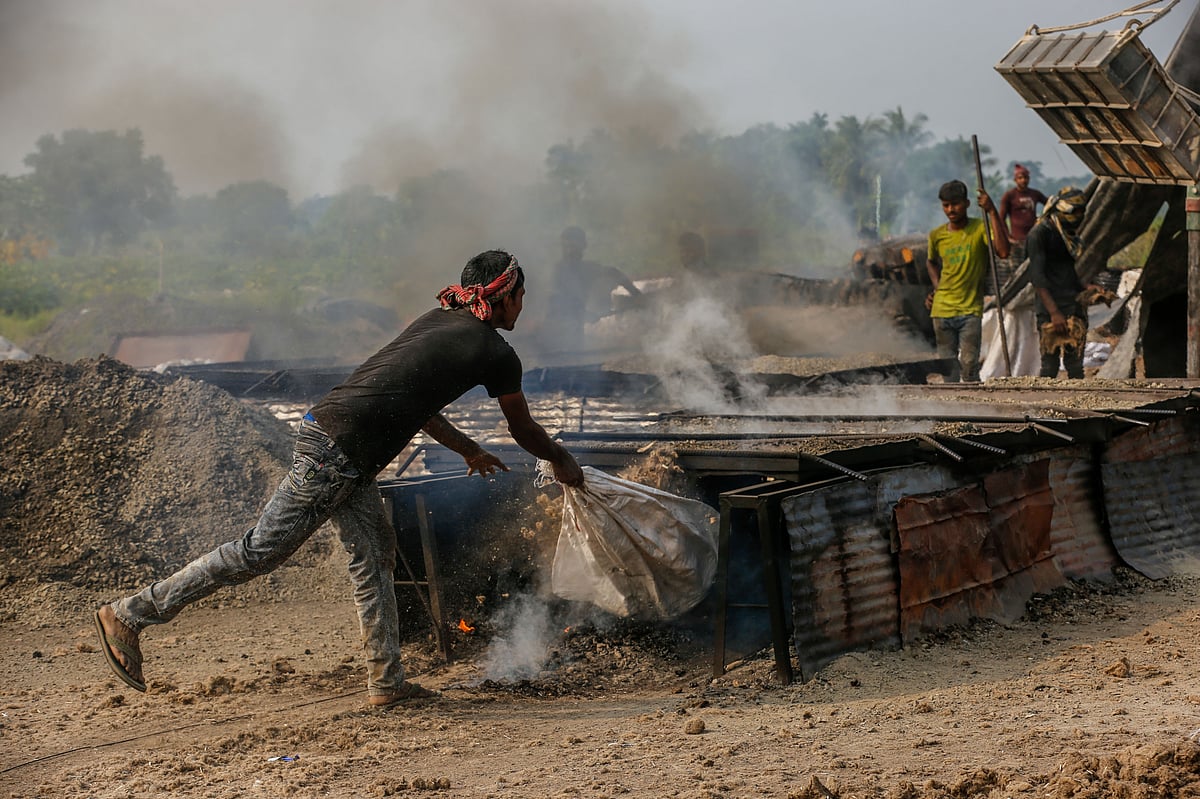 A worker feeding fuel into the furnace.