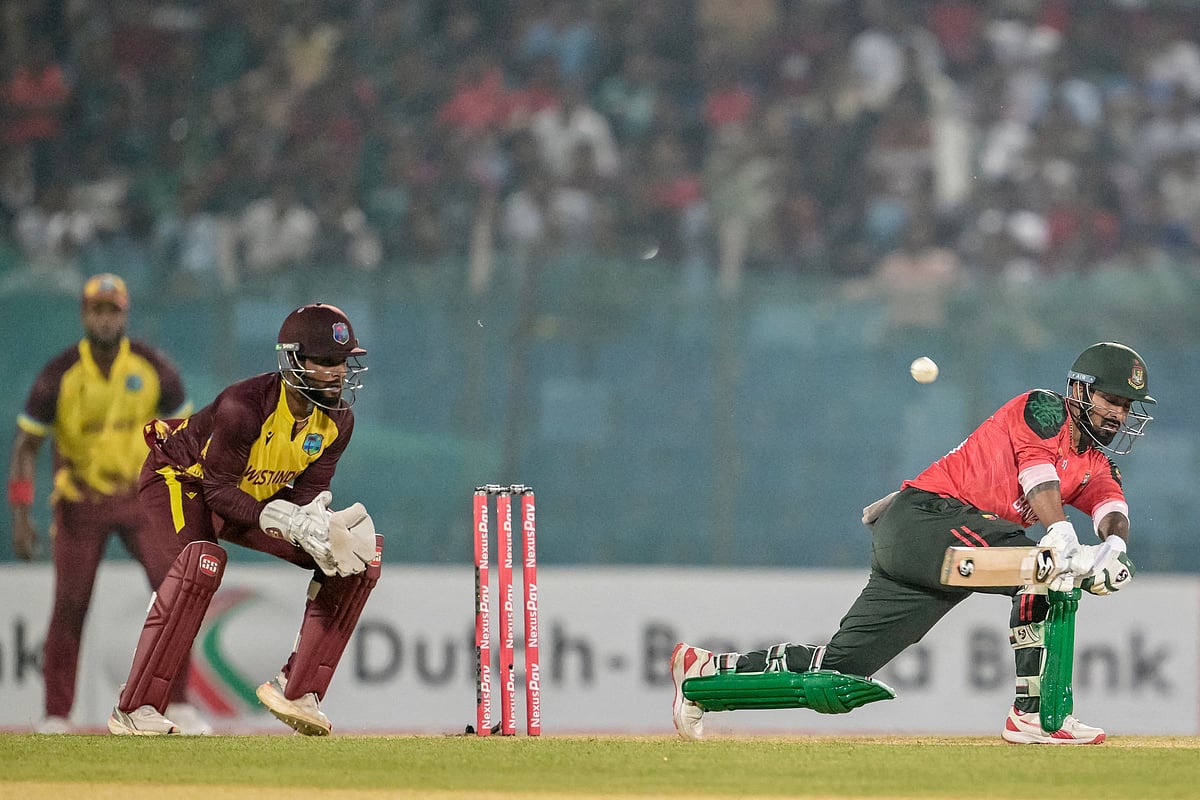 Bangladesh's captain Litton Das (R) plays a shot as West Indies' captain Shai Hope watches during the first Twenty20 international cricket match between Bangladesh and West Indies at a stadium in Chittagong on 27 October, 2025.