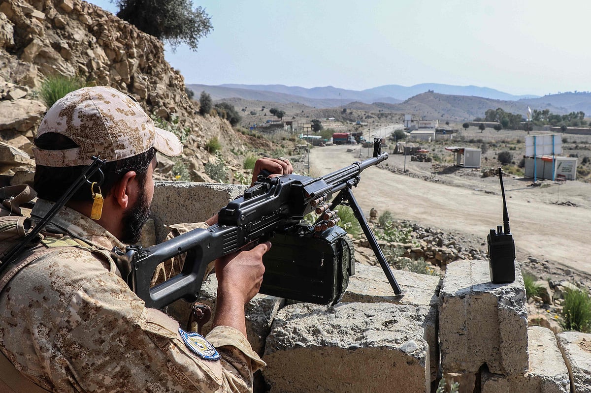 A Taliban security personnel stands guard along a road near the Ghulam Khan zero-point border crossing between Afghanistan and Pakistan in Gurbuz district in the southeast of Khost province on October 20, 2025