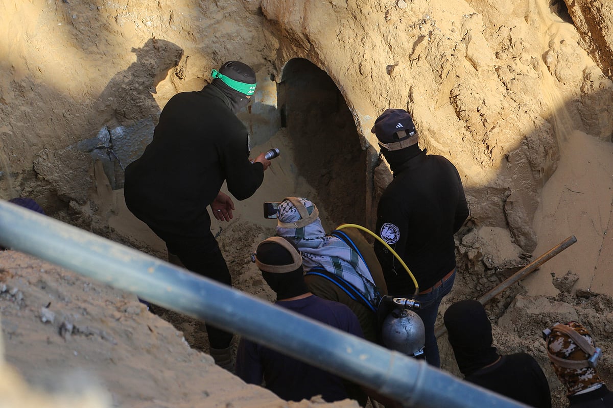 Hamas militants prepare to enter a tunnel to retreive a body in an area north of Khan Yunis in the southern Gaza Strip on 28 October, 2025