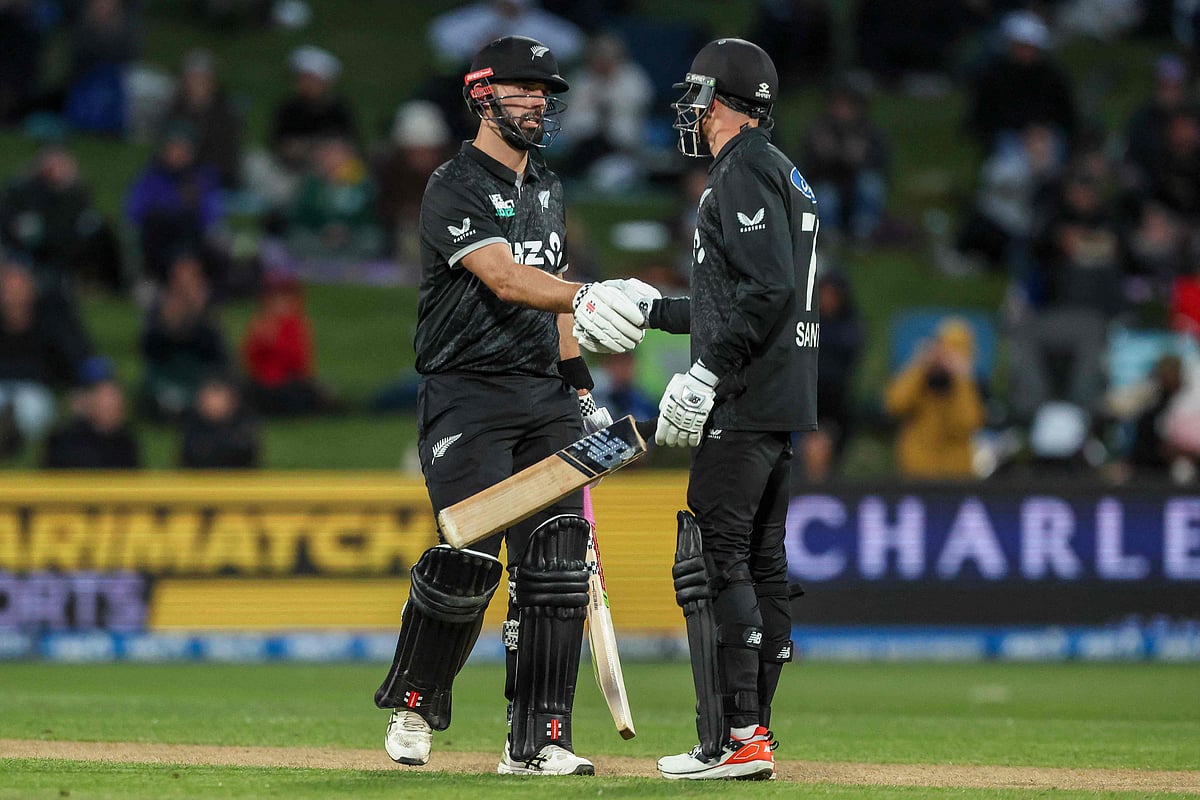 New Zealand’s Daryl Mitchell (L) shakes hands with Mitchell Santner after reaching a half century during the second one-day international (ODI) cricket match between New Zealand and England at Seddon Park in Hamilton on 29 October 2025