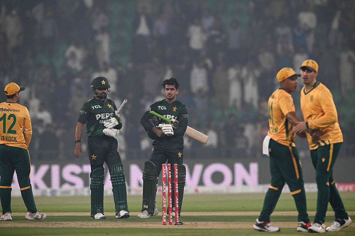 Pakistan's Saim Ayub (C) and Babar Azam (2nd L) walk back after winning the second Twenty20 international cricket match between Pakistan and South Africa at the Gaddafi Cricket Stadium in Lahore on 31 October 2025.
