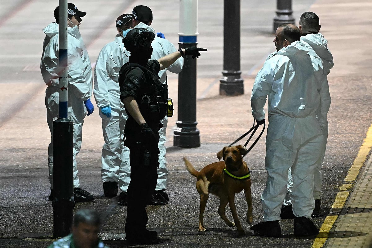 Police officers and a dog handler work on the platform alongside an LNER Azuma train at Huntingdon Station in Huntingdon, eastern England, on November 1, 2025, following a stabbing on a train