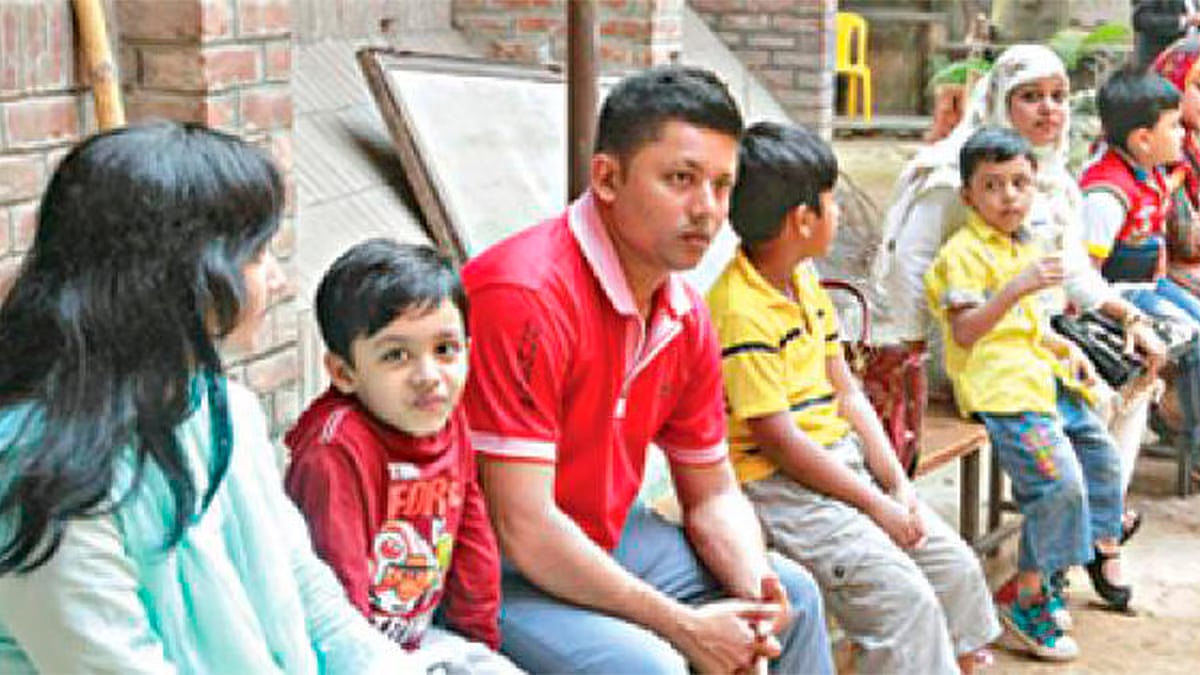 Parents with their children wait on school premises