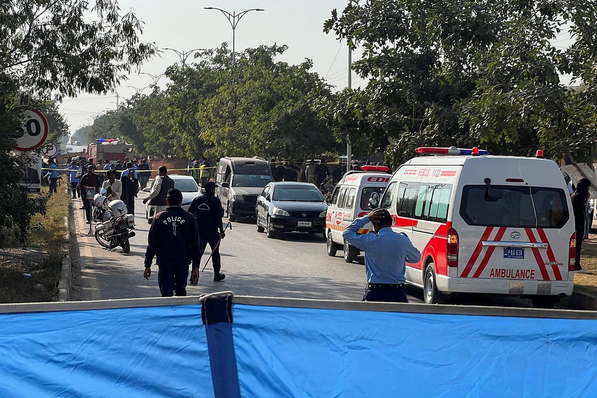 Police officers and ambulances on the road, that is cordoned off, after a blast outside a court building in Islamabad, Pakistan on 11 November 2025