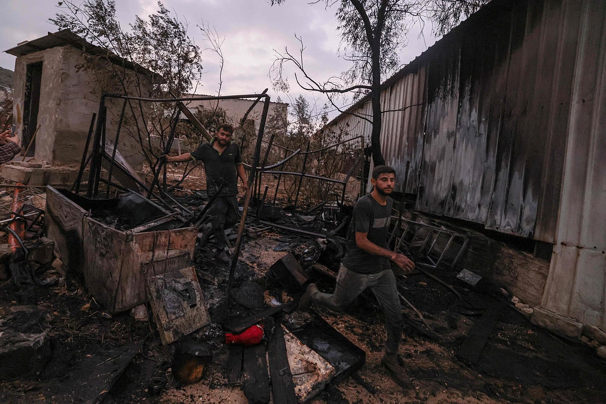 Palestinians inspect parts of a burned house after an Israeli settlers attack in the village of Beit Lid, east of Tulkarm in the occupied West Bank on 11 November, 2025