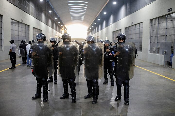 Police officers stand guard during a media tour at the Terrorism Confinement Center (CECOT) prison, in Tecoluca, El Salvador 4 April, 2025.