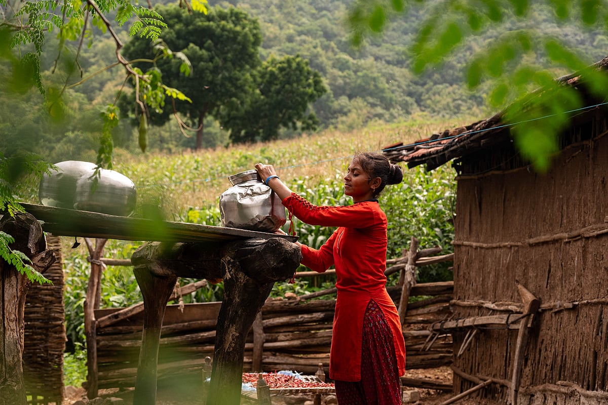 In this photograph taken on September 24, 2025, Ravita, who dropped out of school to manage household chores, balances a filled pot as she walks home after fetching water from river Narmada at Udadya village in the drought-prone district of Nandurbar.