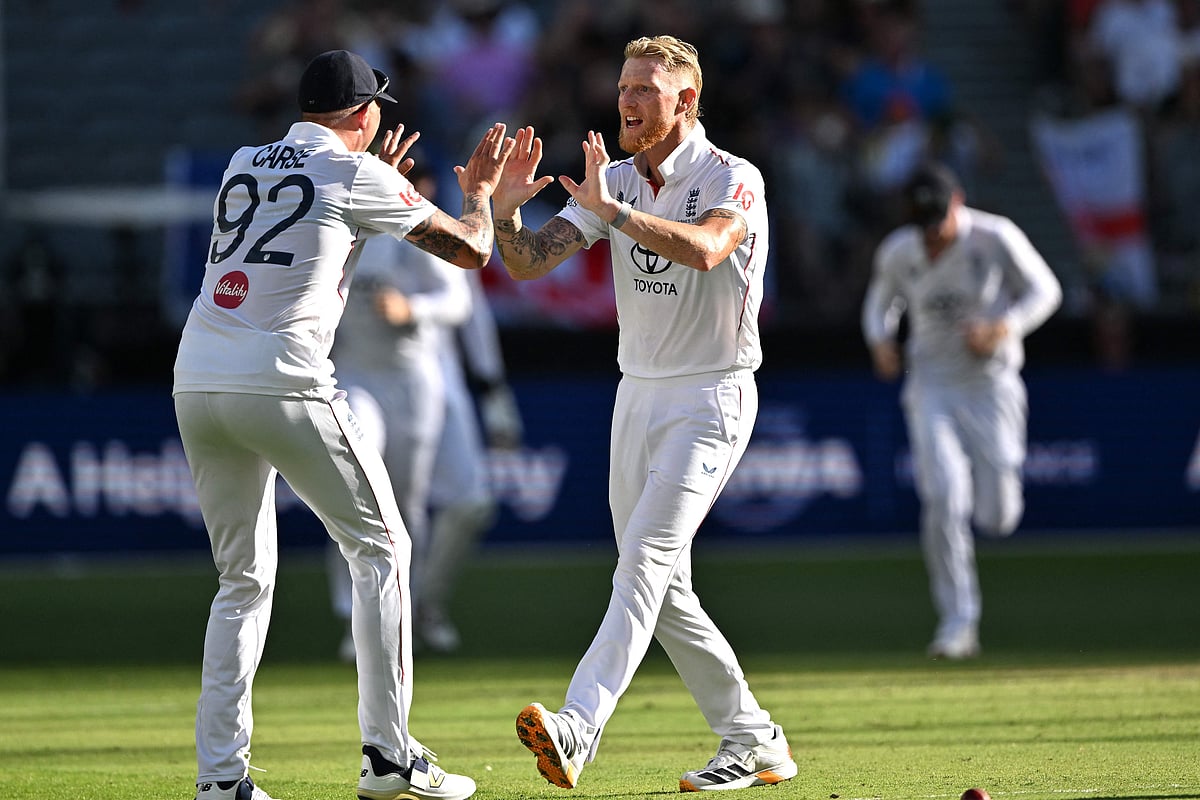 England’s Ben Stokes (R) celebrates his wicket of Australia’s Travis Head with teammate Brydon Carse on day 1 of the first Ashes cricket Test match between Australia and England at Perth Stadium in Perth on 21 November, 2025.