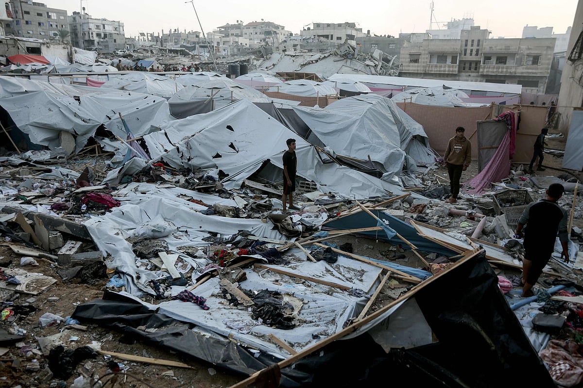 Palestinians are seen surveying the area where displaced people had set up their tent homes, following an Israeli military strike in Gaza City, on 22 November, 2025.