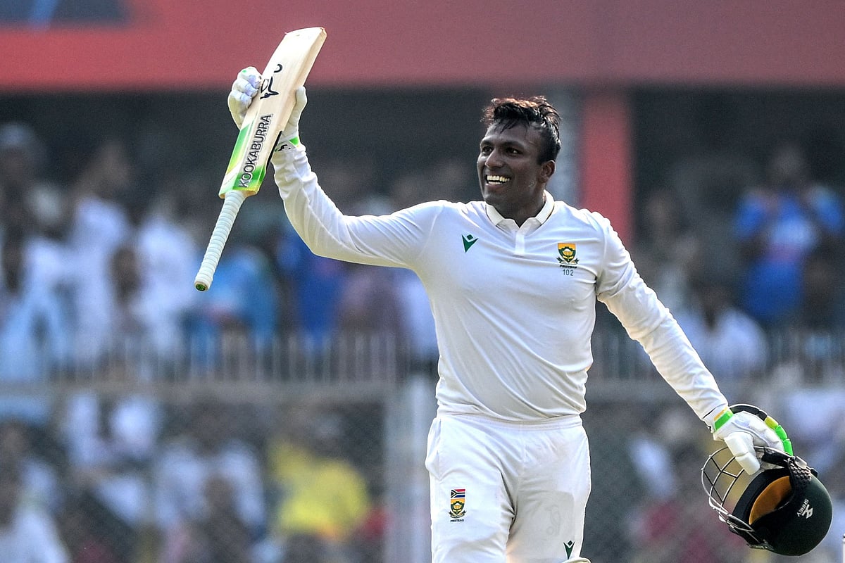 South Africa’s Senuran Muthusamy celebrates after scoring a century (100 runs) during the second day of the second Test cricket match between India and South Africa at the Barsapara Cricket Stadium in Guwahati on 23 November 2025