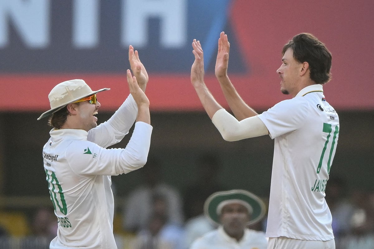 South Africa's Marco Jansen (R) celebrates with teammate Tristan Stubbs after taking the wicket of India's Jasprit Bumrah during the third day of the second Test cricket match between India and South Africa at the Barsapara Cricket Stadium in Guwahati on 24 November, 2025.