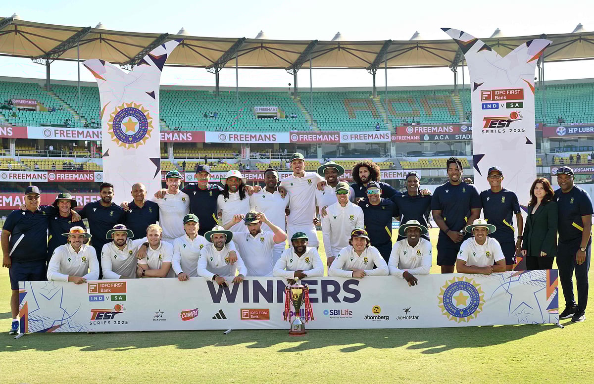 South Africa's players pose with the trophy to celebrate their win in the end of the fifth day of the second Test cricket match between India and South Africa at the Barsapara Cricket Stadium in Guwahati on 26 November, 2025