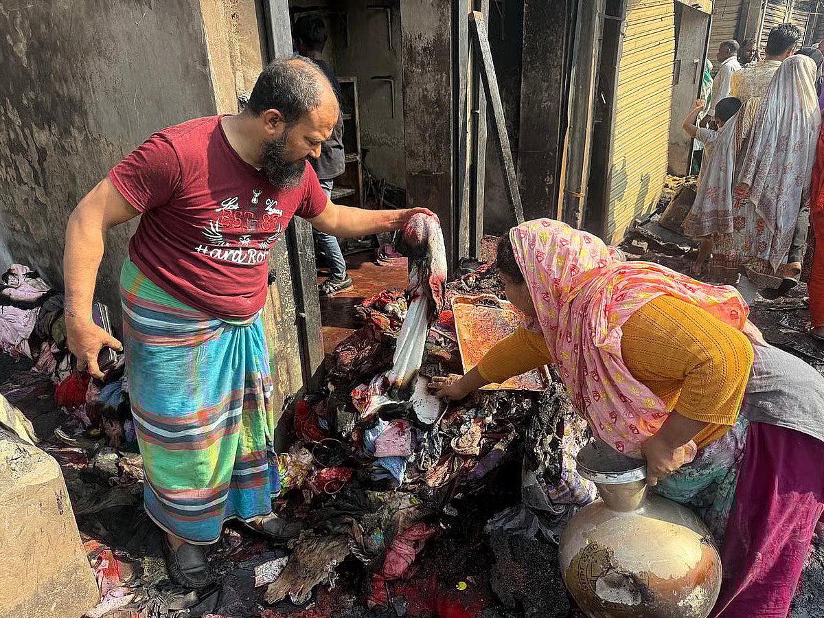 Moyna Begum rummaging charred belongings