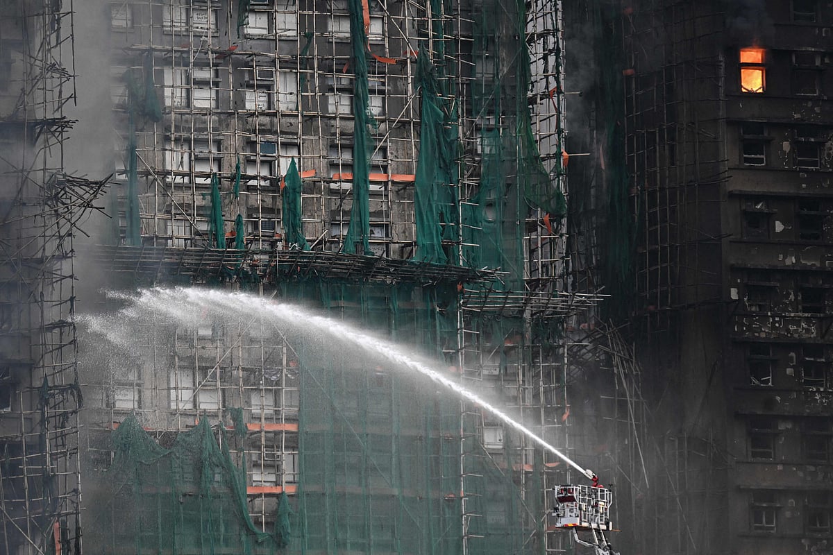 Firefighters spray water on flames as a major fire burns through several apartment blocks at the Wang Fuk Court residential estate in Hong Kong's Tai Po district on 27 November, 2025