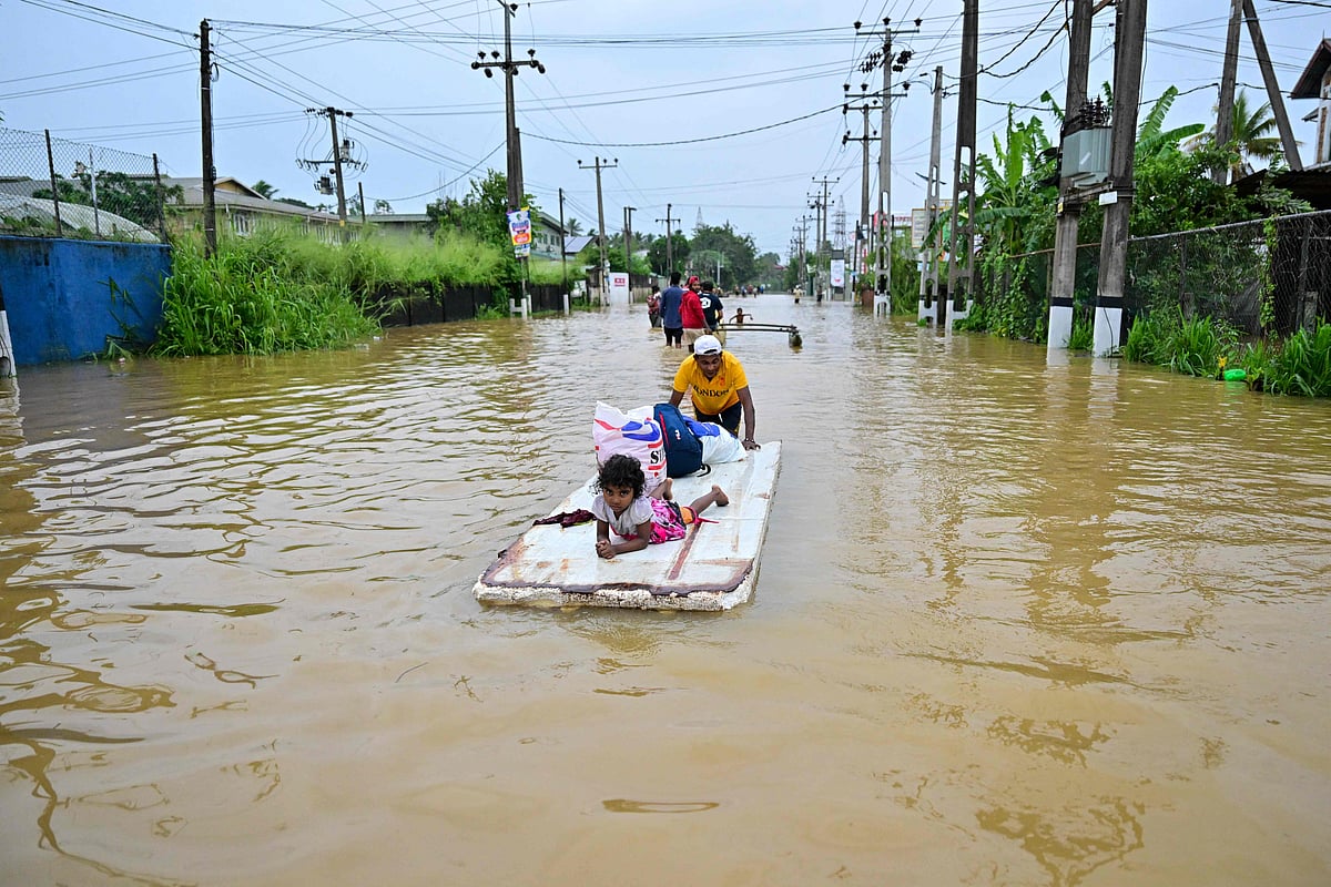A man pushes a makeshift raft along a flooded street in Ambatale on the outskirts of Colombo on 29 November, 2025. Sri Lanka made an appeal for international assistance on 29 November as the death toll from heavy rains and floods triggered by Cyclone Ditwah rose to 123, with another 130 reported missing.
