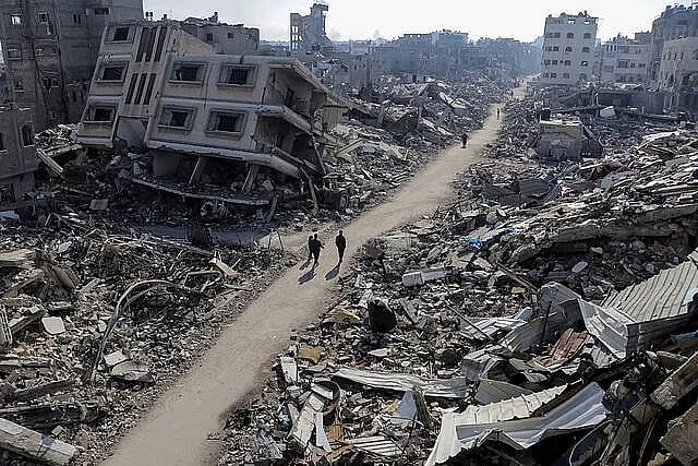 Palestinians walk past destroyed houses, in the northern Gaza Strip, February 22.