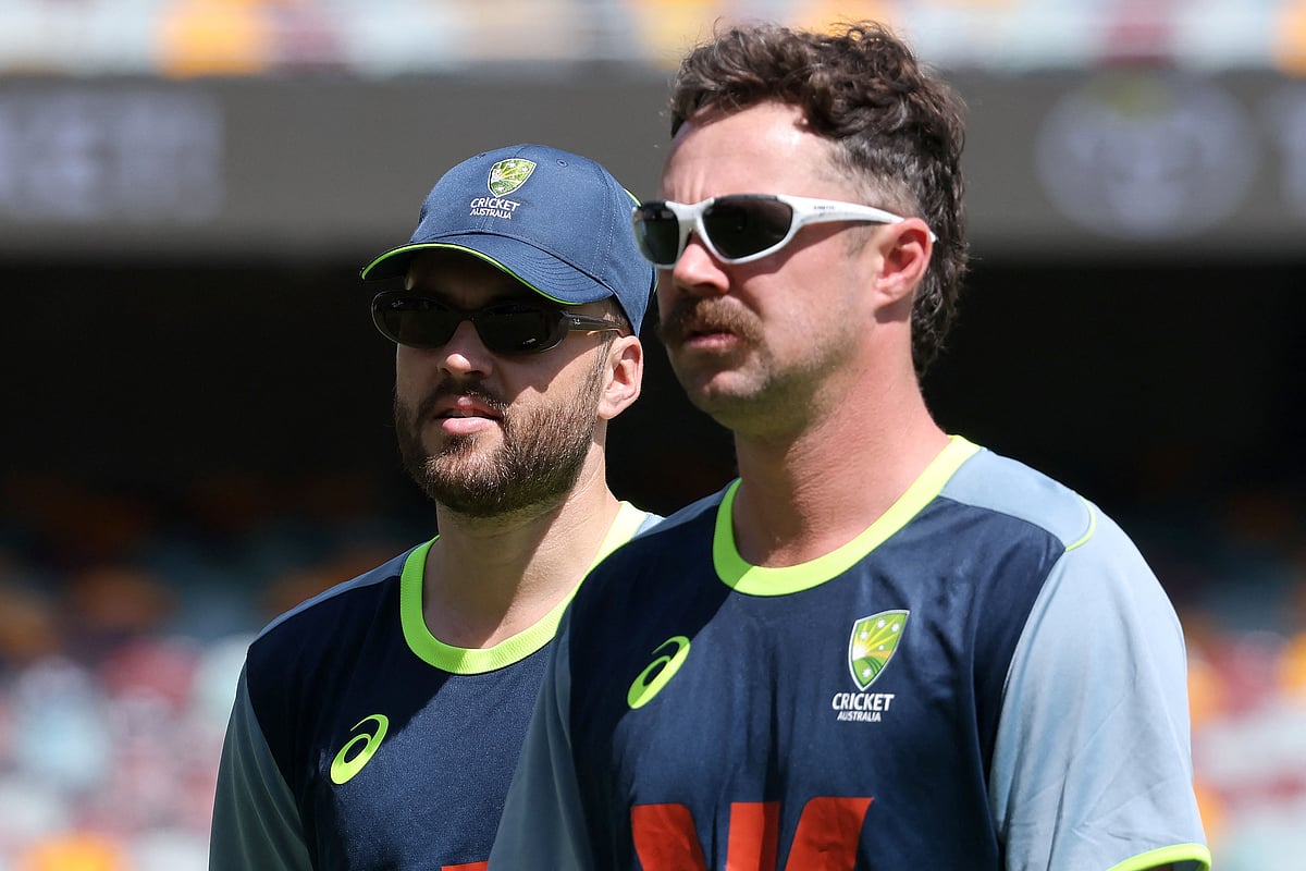 Australia’s Josh Inglis (L) and Travis Head walk onto the field during a practice session at The Gabba in Brisbane on 3 December 2025, ahead of the second Ashes Test