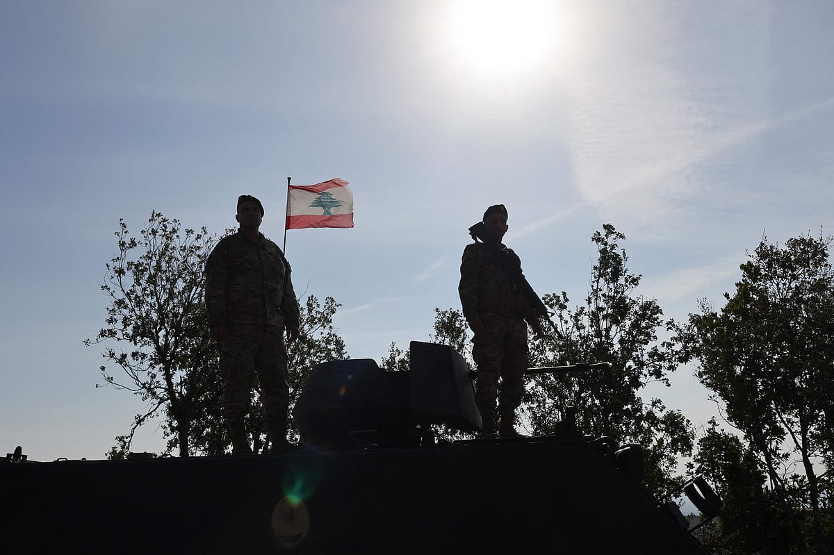This photograph taken during a press tour organised by the Lebanese army shows Lebanese soldiers standing atop a military vehicle in Alma Al-Shaab, near the border with Israel in southern Lebanon, on 28 November 2025.
