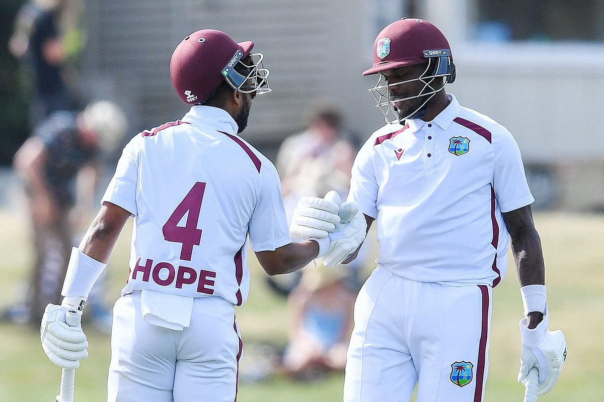 West Indies' Shai Hope (L) is congratulated by Justin Greaves after scoring a century during day four of the first Test cricket match between New Zealand and West Indies at Hagley Oval in Christchurch on 5 December, 2025.