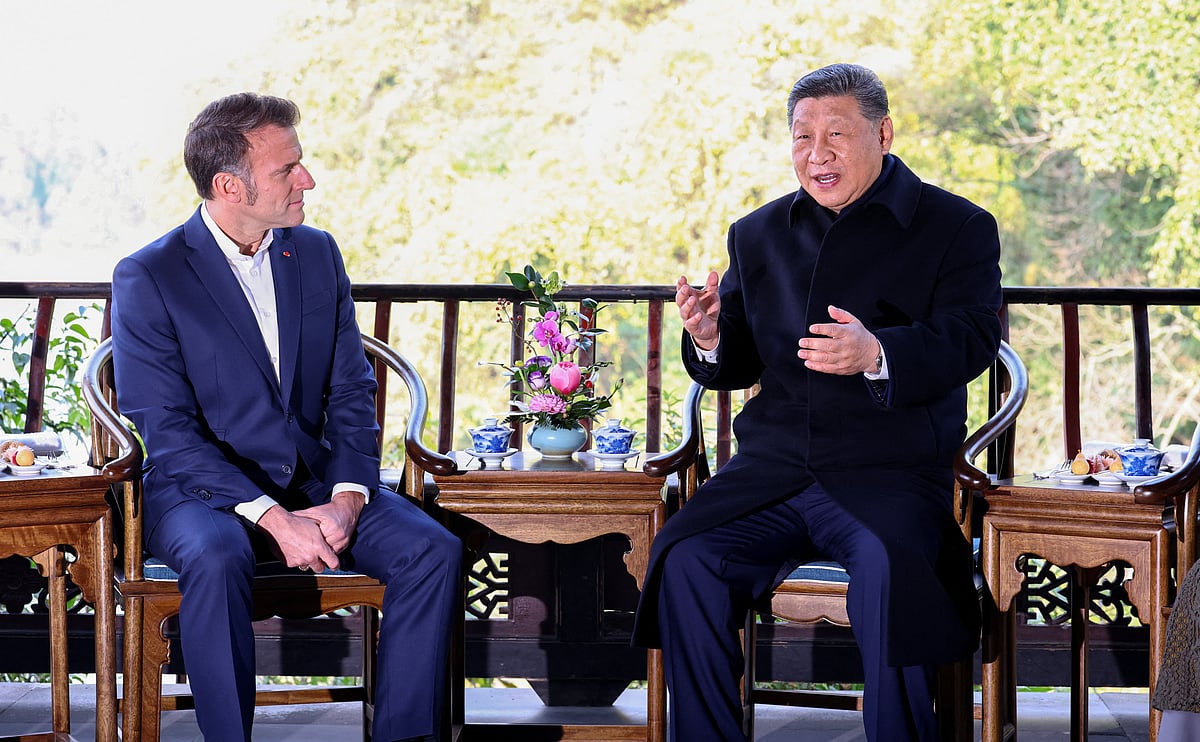 French President Emmanuel Macron and Chinese President Xi Jinping speak during a visit to the Dujiangyan site, designated a UNESCO World Heritage Site, in Dujiangyan, Sichuan province, as part of Macron's three-day visit to China, 5 December 2025.