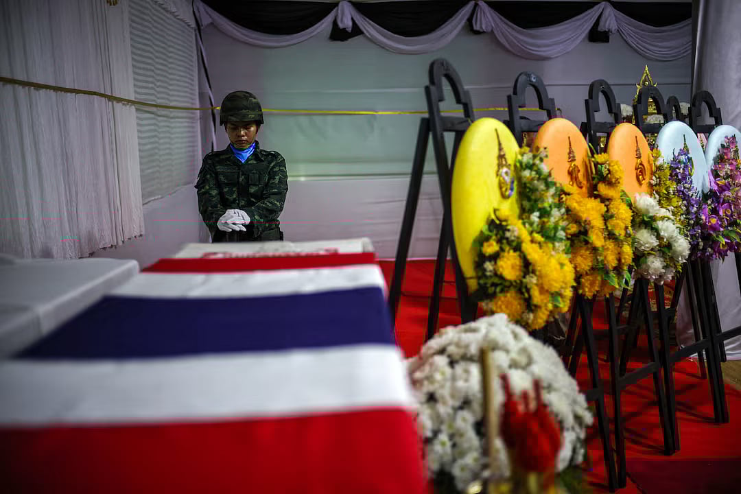 A soldier salutes next to a coffin of Sergeant Major Ananda Udon, 39, a Thai soldier who died on 10 December amid clashes between Thailand and Cambodia along a disputed border area, during his funeral at a temple in Si Sa Ket province, Thailand, December, 2025.