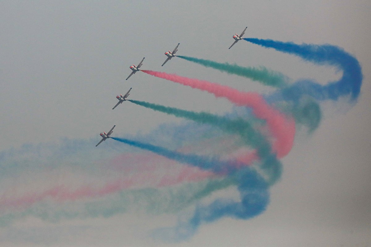 Five aircraft appear together over the sky of the old Tejgaon Airport area, dispersing colours as they fly. After circling several times, the aircraft depart.