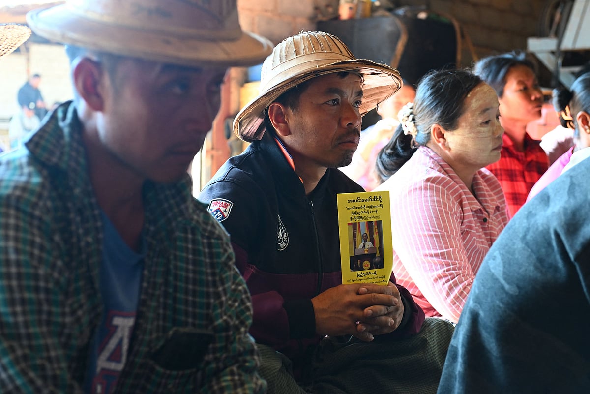 This photo taken on December 9, 2025 shows a man holding an election campaign pamphlet at a People's Party event ahead of Myanmar's general election in Nawnghkio in Myanmar’s northern Shan State