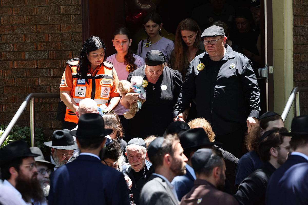 Valentyna (C), the mother of 10-year-old Matilda, who was killed in the December 14 Bondi Beach shooting attack, leaves behind her daughter's coffin after the funeral service in Sydney on December 18, 2025.