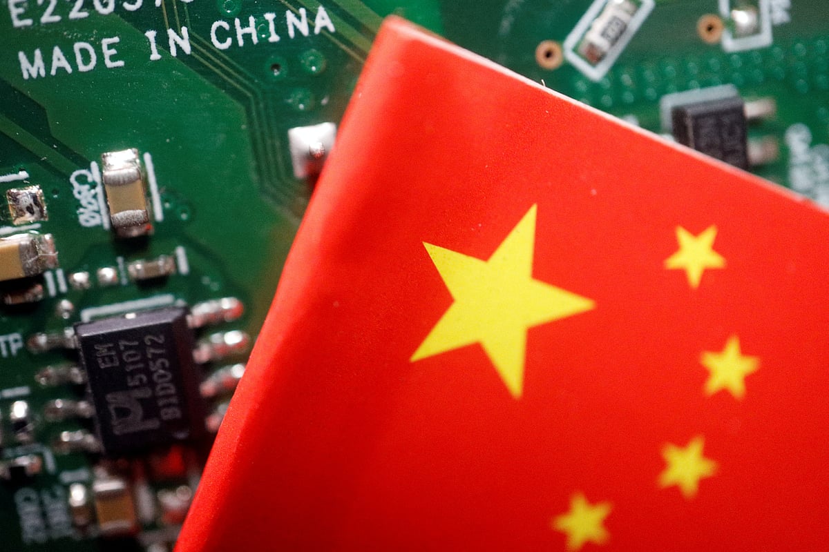 A Chinese flag is displayed next to a "Made in China" sign seen on a printed circuit board with semiconductor chips, in this illustration picture taken 17 February 2023.