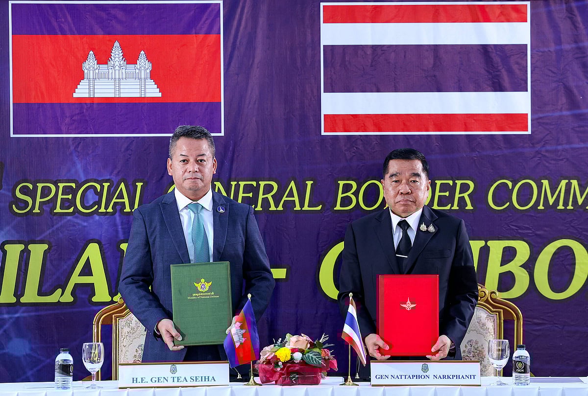 This handout photo released by Agence Kampuchea Press (AKP) on 27 December, 2025 shows Cambodia's defence minister Tea Seiha (L) and Thailand's defence minister Nattaphon Narkphanit (R) posing with documents during the special General Border Committee (GBC) meeting at a border checkpoint in Thailand's Chanthaburi province.