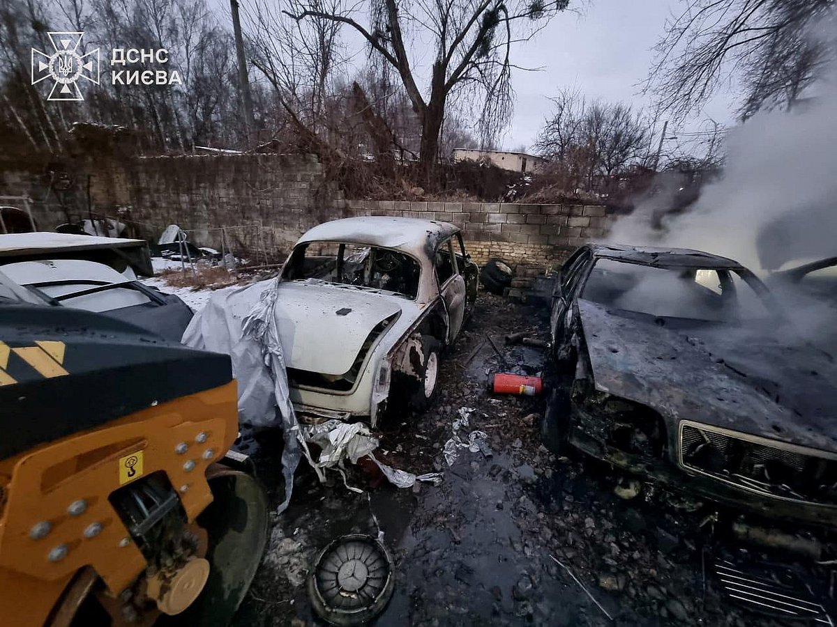Smoke rises from a burnt car at the site of a repair workshop damaged during Russian missile and drone strikes, amid Russia's attack on Ukraine, in Kyiv, Ukraine on 27 December 2025.