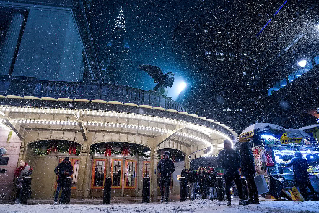 People walk outside of Grand Central Station as snow falls during a winter storm in New York City, US, 26 December, 2025.