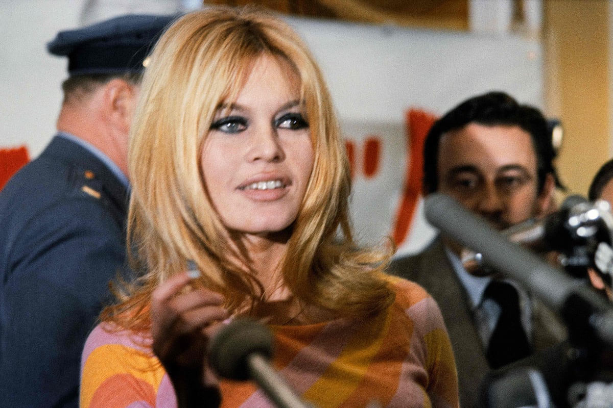 French actress Brigitte Bardot (C) gives a press conference on December 1965 in Hollywood for the film "Viva Maria", directed by Louis Malle (background)