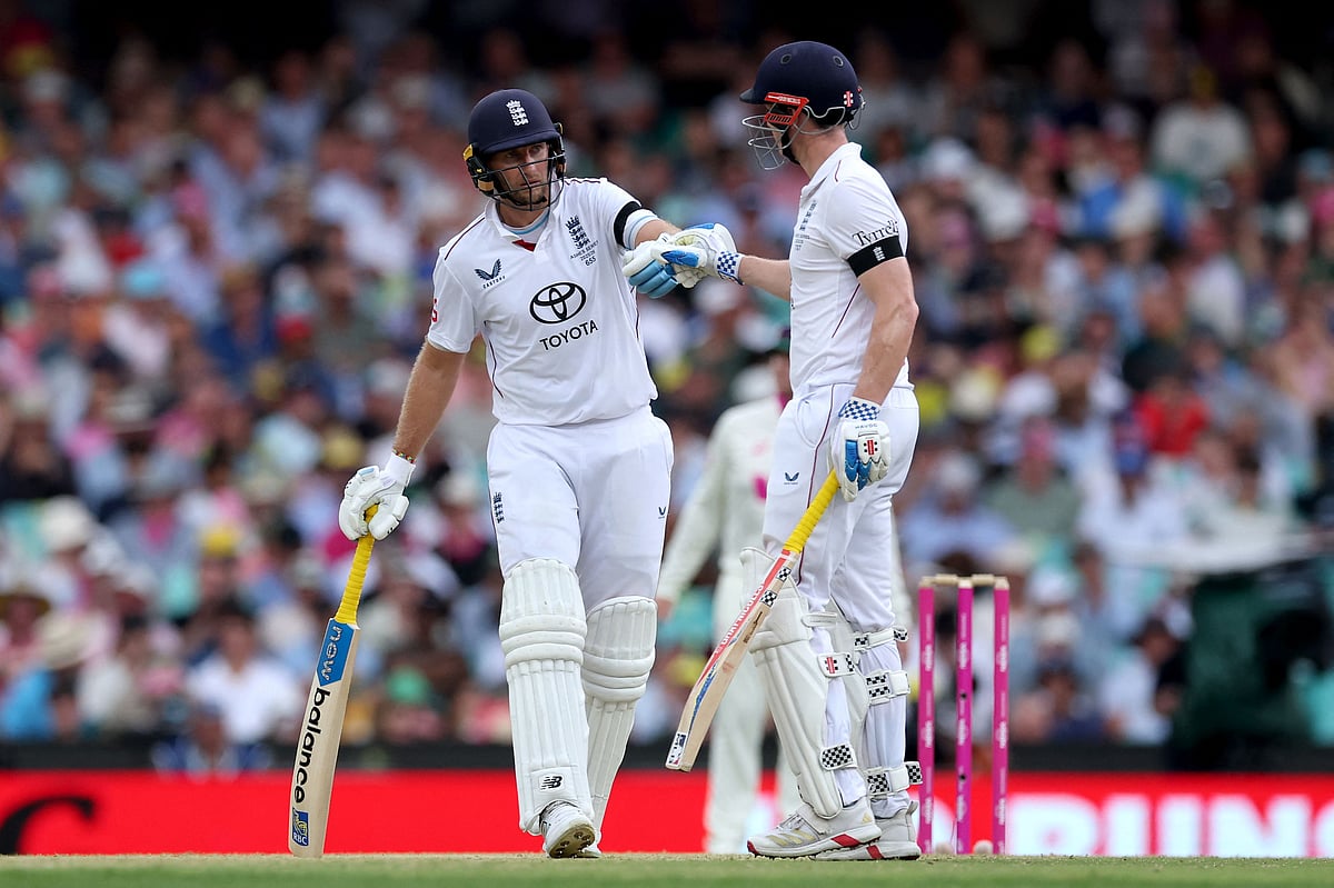 England’s Joe Root (L) and Harry Brook touch gloves on day one of the fifth Ashes cricket Test match between Australia and England at the Sydney Cricket Ground (SCG) in Sydney on 4 January, 2026