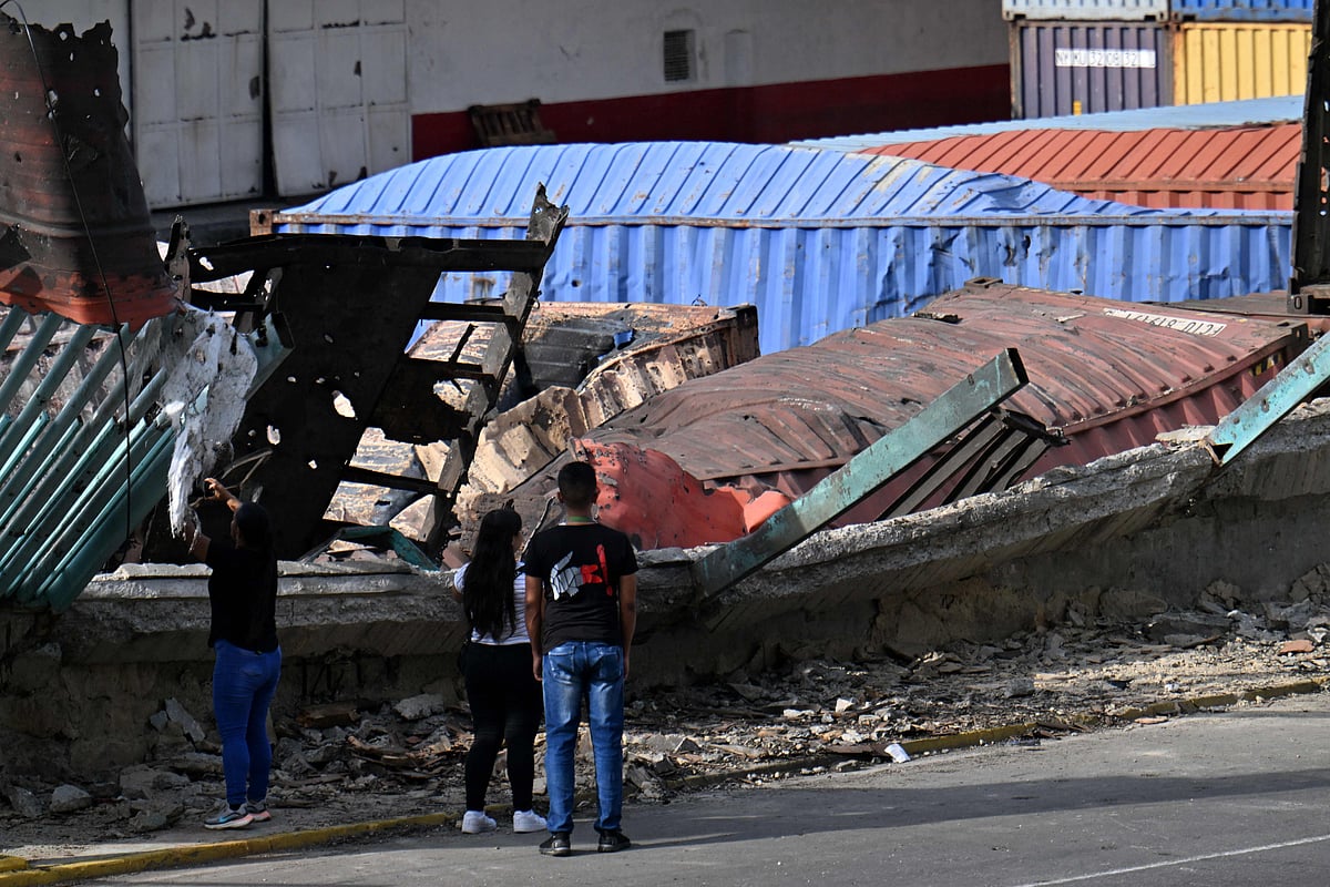 People look at the burnt containers at the Port of La Guaira, Venezuela, on 3 January, 2026, after US forces captured Venezuelan leader Nicolas Madu