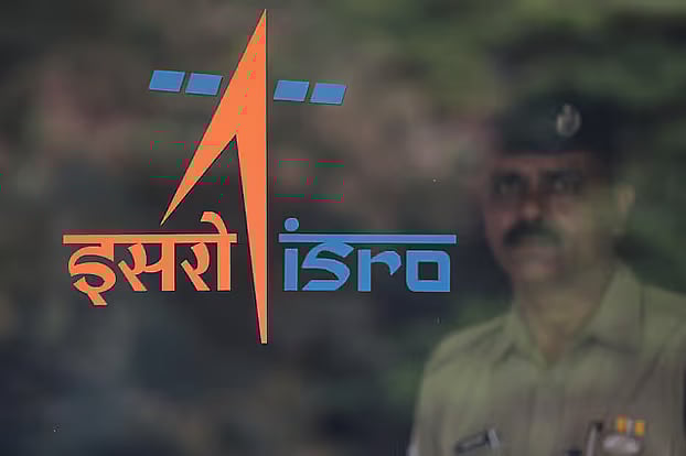 A security guard stands behind the logo of Indian Space Research Organisation (ISRO) at its headquarters in Bengaluru, India, on 12 June, 2019