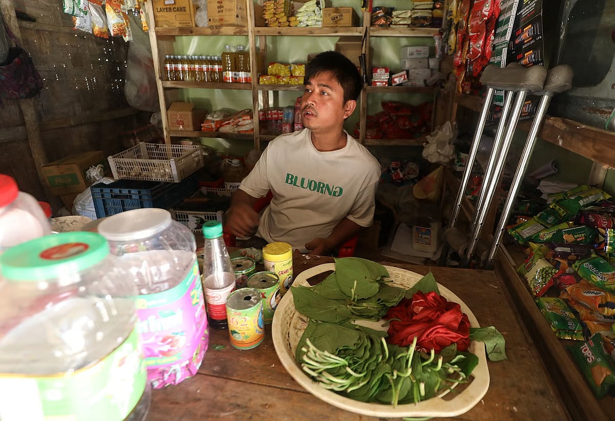 Antai Tanchangya, who lost his leg in a mine explosion, sits in his shop at Tambru Headman Para in Ghummdhum, Naikhongchhari, Bandarban on 14 January 2026. 