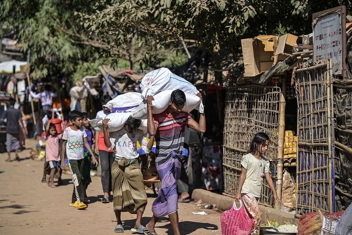 This photograph taken on December 20, 2025 shows Rohingya youths carrying sacks of relief aid at the Kutupalong refugee camp in Ukhia. Cox's Bazar, Bangladesh.