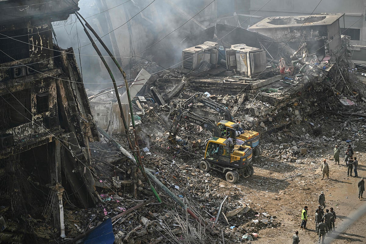 Rescue workers search amid the debris using excavators after a massive fire at a shopping mall in Karachi on 20 January, 2026