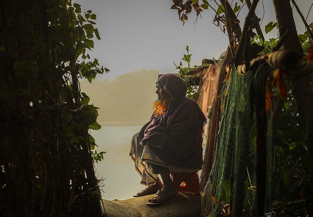An elderly man sits on the banks of the Atai River, basking in the morning sunlight. Katabon, Dighalia, Khulna, 29 January.
