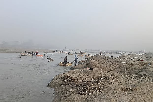 The Mahananda flows between Bangladesh and India. Despite the extreme cold, many people of Tetulia wade into the river to extract sand even before the night ends.Yesterday, Sunday, at 8:00am