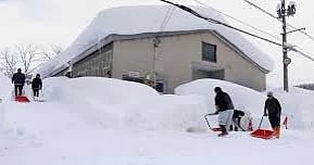 People clear snow near a building in Aomori, northern Japan, Monday, 2 February, 2026.