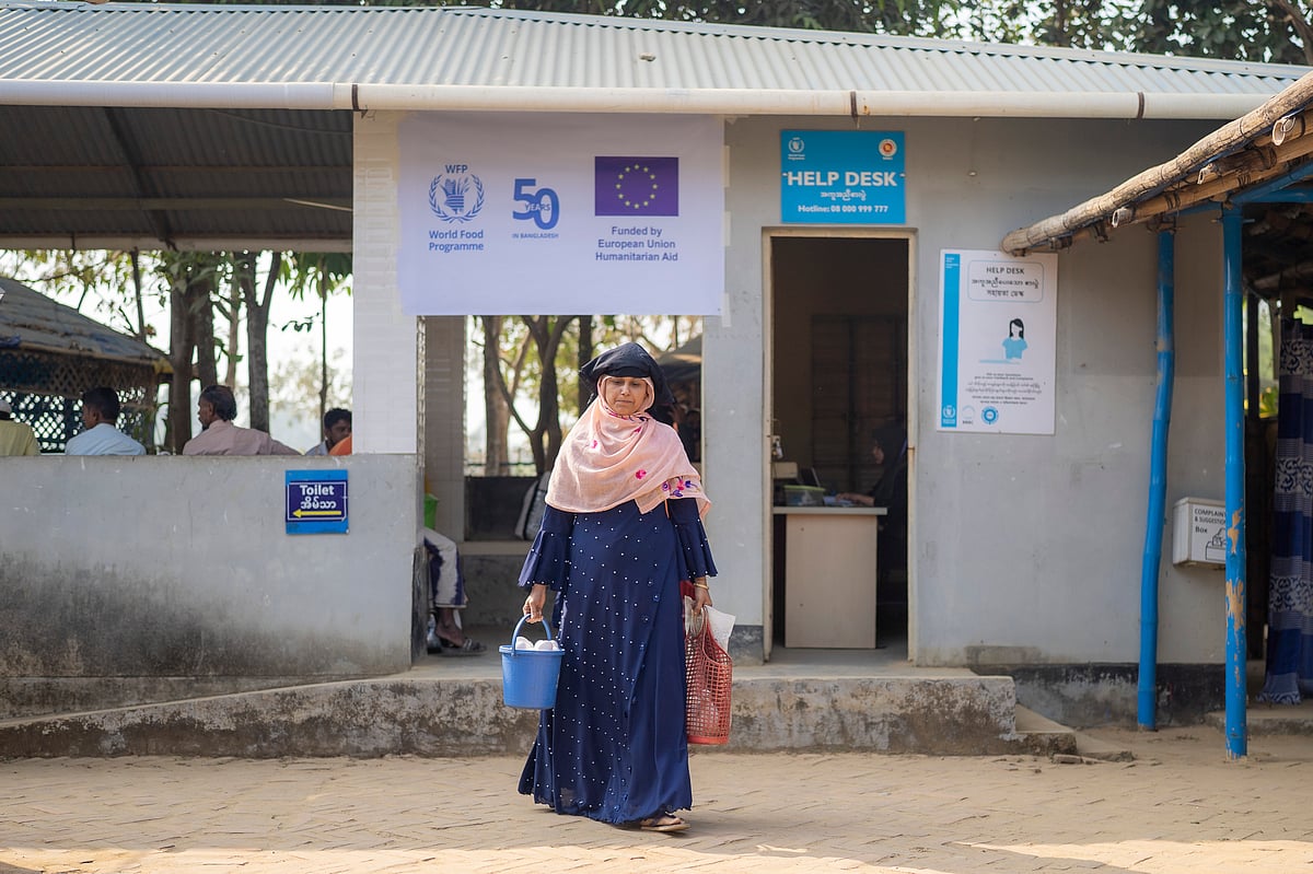 A Rohingya mother going home with the food commodities she bought from WFP e-voucher outlet.